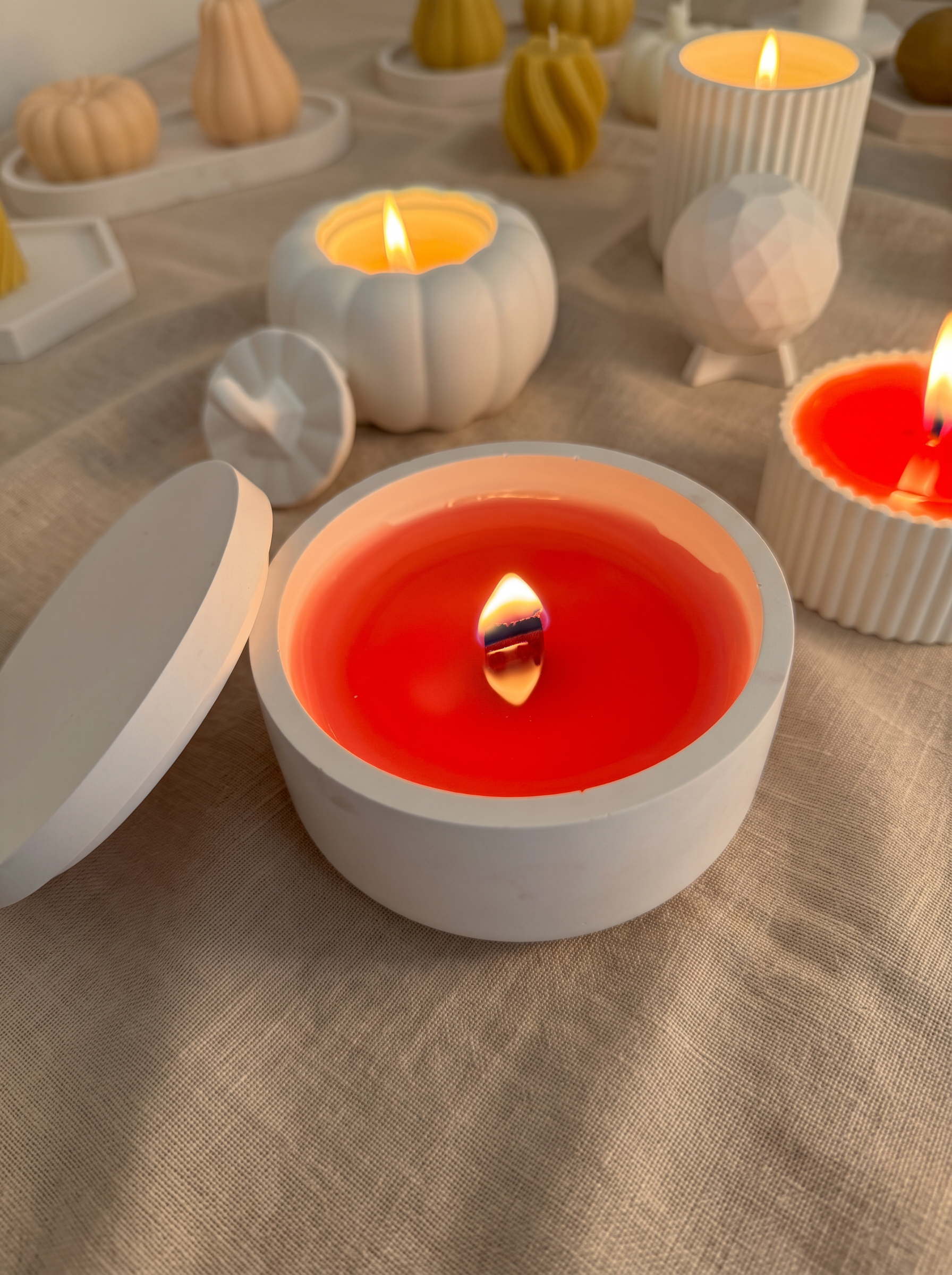 Bougies artisanales allumées sur une nappe en lin beige
